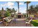 Stone fireplace with comfortable seating area, ideal for outdoor relaxation at 22926 N De La Guerra Ct, Sun City West, AZ 85375