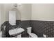 Elegant powder room with dark gray tile and a pedestal sink at 22926 N De La Guerra Ct, Sun City West, AZ 85375