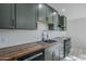 Modern kitchen features dark green cabinets and a wood countertop at 1323 W Tuckey Ln, Phoenix, AZ 85013