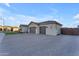 View of the home's side, showcasing a three-car garage and gated driveway at 21559 E Russet Rd, Queen Creek, AZ 85142