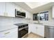 Modern kitchen with white cabinets, marble countertops, and a stylish backsplash at 25240 S Mohawk Dr, Sun Lakes, AZ 85248