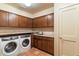 Bright laundry room, washer, dryer, granite countertops, and ample wood cabinets at 25255 N Ranch Gate Rd, Scottsdale, AZ 85255