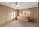 Bedroom with wood paneling, ceiling fan, dresser, and walk-in closet at 4065 E University Dr # 529, Mesa, AZ 85205