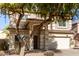 Two-story house with tan exterior, large windows, and a two-car garage at 44344 W Knauss Dr, Maricopa, AZ 85138