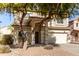 Two-story house with tan exterior, large windows, and a two-car garage at 44344 W Knauss Dr, Maricopa, AZ 85138