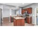 Modern kitchen with island, stainless steel appliances and view to living room at 44344 W Knauss Dr, Maricopa, AZ 85138