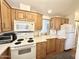 Simple kitchen featuring wood cabinets and white appliances at 870 S Motherlode Dr, Apache Junction, AZ 85119