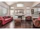 Living room with red sofa, fireplace, and hardwood floors at 15516 W Meadowbrook Ave, Goodyear, AZ 85395