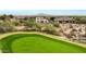 Aerial perspective of homes near a golf course with mountain backdrop at 3414 N Park St, Buckeye, AZ 85396