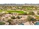 Aerial view of homes, a golf course, and a pool; mountain views at 3414 N Park St, Buckeye, AZ 85396