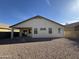 Desert landscape surrounds this home's backyard, which includes a covered patio at 4544 N 129Th Ave, Litchfield Park, AZ 85340