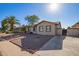 Tan house with a landscaped yard, driveway, and a partial view of the street at 5209 W Mauna Loa Ln, Glendale, AZ 85306