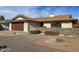 Front view of a ranch home with a stone wall and gravel landscaping at 10956 W Meade Dr, Sun City, AZ 85351