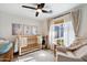 Bedroom with crib, armchair, and plenty of natural light at 4015 E Catalina Dr, Phoenix, AZ 85018