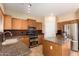 Kitchen with island, stainless steel appliances, and wood cabinets at 45335 W Rhea Rd, Maricopa, AZ 85139