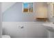 Clean bathroom with pedestal sink, wood shelf, and white wainscoting at 10015 N 14Th St # 7, Phoenix, AZ 85020