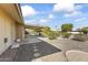 Covered patio and gravel backyard with mature landscaping at 10521 W Prairie Hills Cir, Sun City, AZ 85351