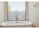 Relaxing bathroom with freestanding soaking tub and large window at 10587 E Caron St, Scottsdale, AZ 85258