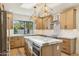 Modern kitchen with marble island and light wood cabinets at 10587 E Caron St, Scottsdale, AZ 85258