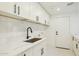 Clean laundry room with white cabinets and a large sink at 10587 E Caron St, Scottsdale, AZ 85258