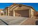 Two-car garage with large driveway and desert landscaping at 21836 W Hopi St, Buckeye, AZ 85326