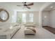 Bright living room with white couches, a ceiling fan, and large windows at 4510 N Pierce Ct, Buckeye, AZ 85396