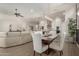 Bright dining room with modern chandelier and seating for six at 5273 N 207Th Dr, Buckeye, AZ 85396