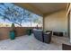 Relaxing covered patio with seating area,desert landscaping, and tile flooring at 5273 N 207Th Dr, Buckeye, AZ 85396