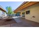 Covered patio, gravel yard, and mature trees at 10417 E Watford Way, Sun Lakes, AZ 85248