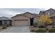 Beige house with two-car garage and landscaping at 12461 W Midway Ave, Glendale, AZ 85307