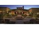 Inviting clubhouse entrance with a courtyard and benches at night at 7674 W Cactus Wren Way, Florence, AZ 85132