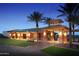 Elegant clubhouse exterior at night with palm trees and landscaping at 7674 W Cactus Wren Way, Florence, AZ 85132