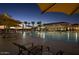Evening view of community pool with lounge chairs and umbrellas at 7674 W Cactus Wren Way, Florence, AZ 85132