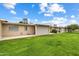 Private backyard with patio, grassy area, and mature trees at 10404 W Audrey Dr, Sun City, AZ 85351