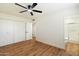 Bedroom with hardwood floors, ceiling fan, and attached bathroom at 10404 W Audrey Dr, Sun City, AZ 85351