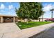 Ranch home with carport, mature tree, and well-manicured lawn at 10404 W Audrey Dr, Sun City, AZ 85351