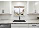 Modern kitchen sink with marble countertops and a view from the window at 10404 W Audrey Dr, Sun City, AZ 85351
