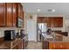 Well-equipped kitchen with stainless steel appliances and dark wood cabinets at 2801 W Silver Fox Way, Phoenix, AZ 85045