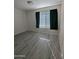 Bright bedroom with grey laminate flooring and window at 306 E Ludlow Dr # A, Avondale, AZ 85323