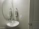 Small bathroom with pedestal sink and oval mirror at 35262 W San Ildefanso Ave, Maricopa, AZ 85138