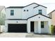 Two-story home with white exterior, black garage door, and landscaping at 5720 S Daisy Patch Pl, Phoenix, AZ 85040