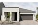 Modern home with white stucco exterior, dark brown garage door, and small landscaping at 5818 S Daisy Patch Pl, Phoenix, AZ 85040