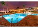 Inviting lighted pool area with patio furniture at night at 6097 S Pinehurst Dr, Chandler, AZ 85249