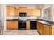 Well-equipped kitchen featuring wood cabinets, granite counters, and modern appliances at 7318 W Greer Ave, Peoria, AZ 85345