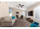 Spacious living room with a large TV, comfortable seating, and ample natural light at 7318 W Greer Ave, Peoria, AZ 85345