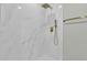 Large shower with marble tile and gold fixtures at 7538 E Garfield St, Scottsdale, AZ 85257