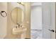 Powder room with pedestal sink and round mirror at 10843 E La Junta Rd, Scottsdale, AZ 85255