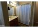 Bathroom with shower/tub combo, vanity, and striped shower curtain at 333 E Redwood Ln, Phoenix, AZ 85048