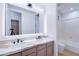 Modern bathroom with double sinks, marble countertops, and a lit mirror at 1270 E Baranca Rd, Gilbert, AZ 85297