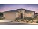 Single-story home with neutral color scheme and landscaped front yard at 16712 W Whispering Wind Dr, Surprise, AZ 85387